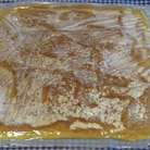 Бисквит с пергаментом положить на кухонное полотенце,посыпать оставшемся сахаром и накрыть пищевой плёнкой (таким образом внутри бисквита сохранится влажность и он не треснет при скручивании).