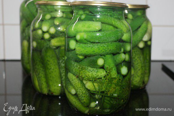 Заполнить банки огурцами и залить кипятком на 2 минуты (на литровую банку), 5 минут (на трехлитровую банку).