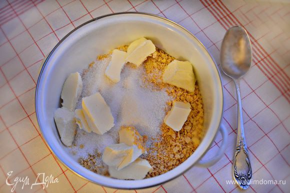 Em uma tigela, combine flocos esmagados, açúcar e manteiga amaciada.