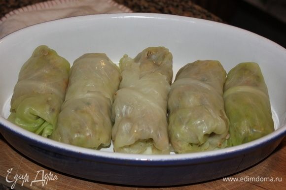 Скрутить голубцы. На капустные листья выкладываем начинку, утрамбовывая ложкой, и начинаем закручивать плотным валеком лист. Выложить один за другим в огнеупорную посуду.